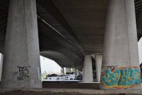 Vrachtschip vaart onder betonnen brug met pilaren door