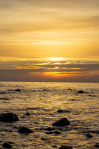 Sonnenuntergang am Strand mit großen Felsen im Wasser an der Ostsee auf Rügen