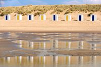 Beach houses reflected in the water of the sea