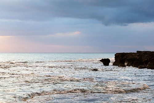 Zonsondergang aan de kust in Jamaica, met turquoise zee en blauw roze lucht.