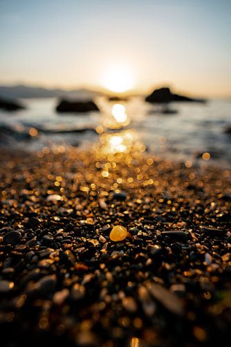 een fonkelende steen op het strand bij zonsopgang