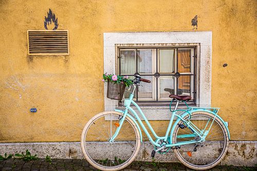 Vélo turquoise contre un mur jaune