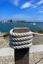 White rope tied around a wooden post at the harbour by Theodor Decker