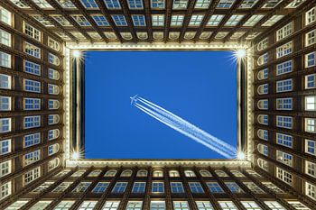 Hamburger Innenhof mit einem Flugzeug am Himmel