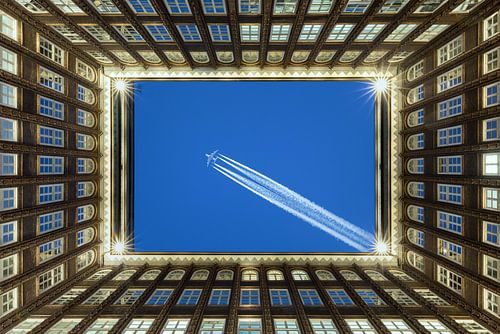 Hamburger Innenhof mit einem Flugzeug am Himmel