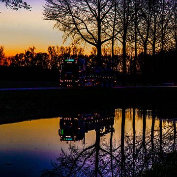 Beleuchteter LKW spiegelt sich im Wasser des Flusses Linge von Anne Ponsen