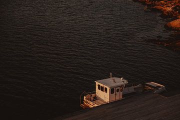 Boot in haven bij zonsondergang in Noordse fjord van Joyce van Doorn