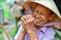 Fröhliche vietnamesische Frau mit Strohhut