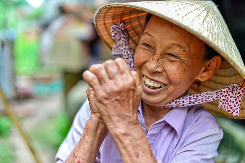 Vrolijke Vietnamese vrouw met strohoed