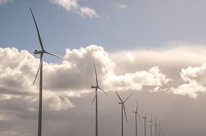 Windkraftanlagen mit blauem Himmel und weißen Wolken im Hintergrund