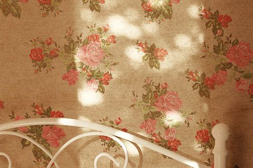 Retro behangmuur met rozenpatroon, badend in warm zonlicht met zachte bokeh highlights