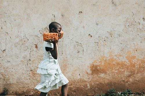 Een Oegandees meisje werkt om te overleven