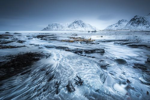 Noors landschap met strand en bergen in de winter.
