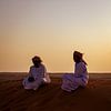 Deux Omanais parlant au coucher du soleil dans le désert sur Lisette van Leeuwen
