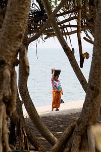 Een Balinese vrouw lopend langs het strand von Willem Vernes
