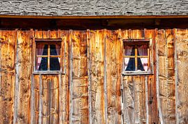 Zwei Holzfenster zieren eine Holzhütte