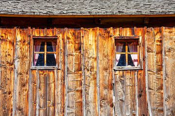 Twee houten ramen sieren een houten hut van Christa Kramer