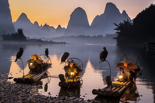 Aalscholvervissers bij zonsondergang