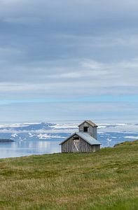 Island: Eine Scheune oder ein kleines Haus an einem Fjord.