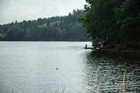 In der Ferne, dieser ein Fischer auf einem sehr großen See.