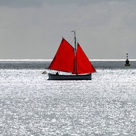Zeilbootje met rood zeil tegen de schittering van de zon op de Waddenzee nabij het eiland Terschelli van Tonko Oosterink