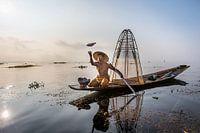FISHERMAN AT SUNRISE vist ON TRADITIONAL WAY TO INLE LAKE IN MYANMAR. With a basket the fish is caug