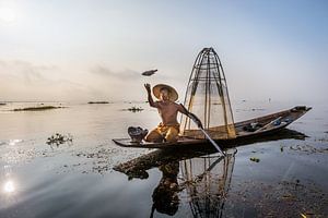 VISSER OP TRADITIONELE MANIER BIJ ZONSOPGANG AAN HET WERK OP HET