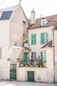 French street scene with pretty facades, green shutters and doors and a terrace