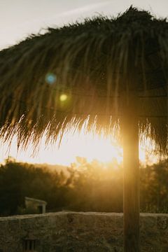 Zonsopkomst onder rieten parasol van Photo Atelier