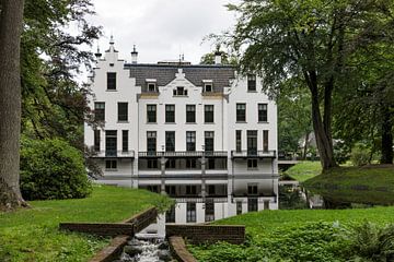Schloss Staverden spiegelt sich im Graben wider und ist umgeben von Naturbäumen und Park.