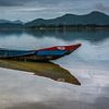 Vissersboot met reflectie in het water. van Adri Vollenhouw
