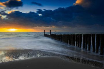 Hollandse wolkenlucht en typische golfbreker van houten palen langs de Zeeuwse kust van gaps photography