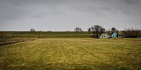 Landschap met dijk, dijkhuizen, grasland en dreigende lucht