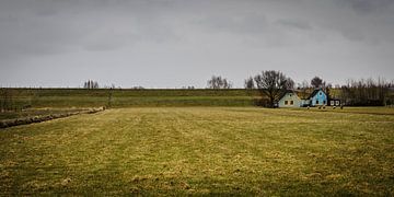 Landschap met dijk, dijkhuizen, grasland en dreigende lucht von Dirk Huckriede