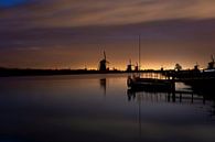 Historische Nederlandse windmolens langs een breed kanaal in Kinderdijk van Tjeerd Kruse thumbnail