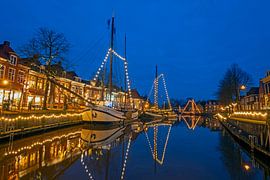 Versierde zeilboten in de haven van Dokkum in Nederland bij avond van Eye on You