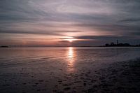 Prachtige zonsondergang met weerspiegeling op het zand