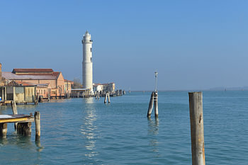 Le phare de Murano se dresse fièrement à côté des bâtiments de la lagune de Venise