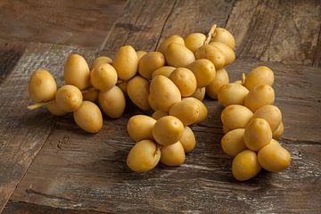 Takken met verse gele rijpe dadels op houten tafel van Frans Rombout