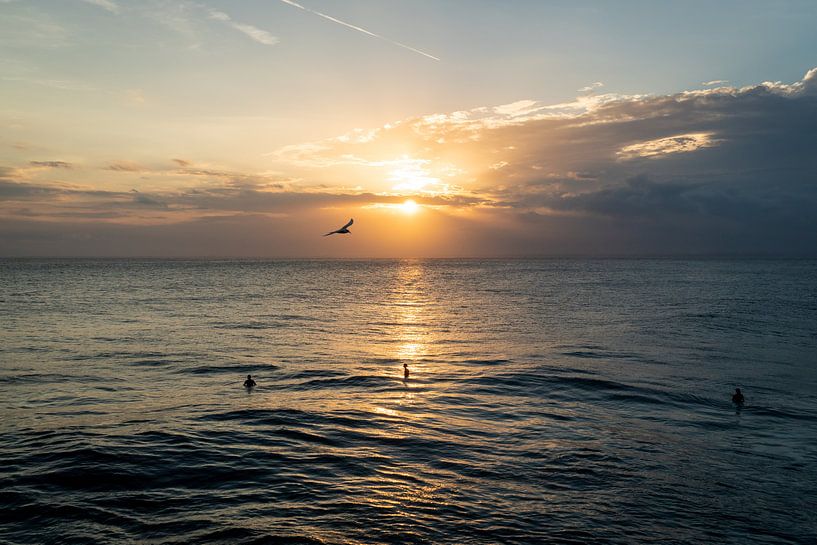 Zonsondergang met surfers in het water en een vogel in de lucht van Bali Nusa Lembongan, Indonesie van Twan Bankers