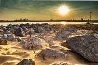 Sonnenuntergang an der Waal bei Nimwegen mit den Felsen des Flusses am Ufer.