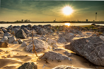 Sunset on the river Waal near Nijmegen with the rocks of the river on the foreshore.