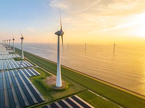 Windturbinen und Sonnenkollektoren an einem Seeufer