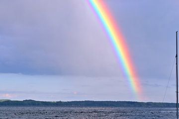 A double rainbow over a lake before a thunderstorm