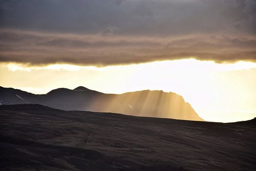 Zonnestralen boven een berg