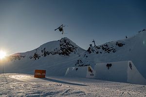 Skiër vliegt hoog boven de bergtoppen van Hidde Hageman