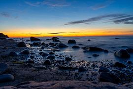 Wundervoller Sonnenuntergang am Strand der Ostsee auf Rügen mit Steinlandschaft am Kap Arkona