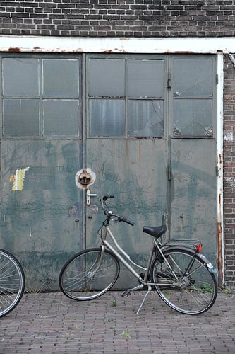 Damesfiets voor deuren van werkplaats - haven Delft