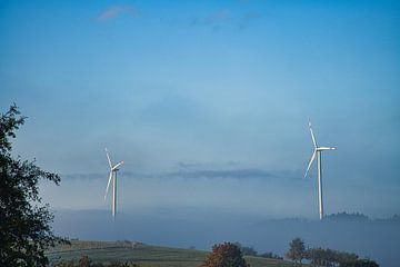 Wind turbine in fog on a meadow by Martin Köbsch