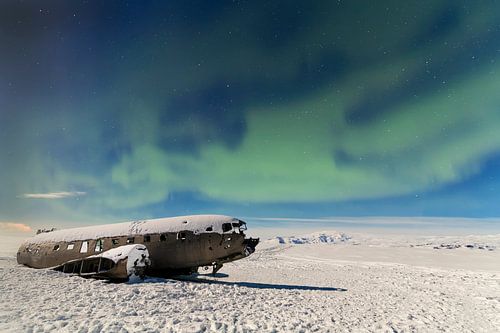 Dakota on Sólheimasandu's beach with Aurora Borealis